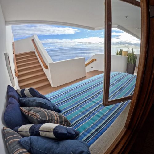 - Recline on a striped daybed with cozy pillows, just steps from your private stairway to the sea
- Floor to ceiling views flood in through open windows for a breezy, indoor outdoor feel
- Serene nook perfect for afternoon naps or reading